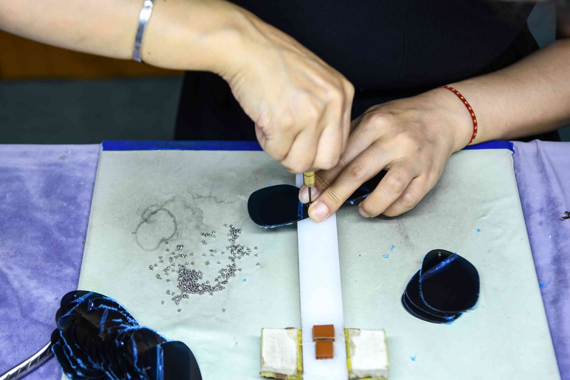 Assembling sunglasses lenses and temples on a precision jig at HAO Eyewear