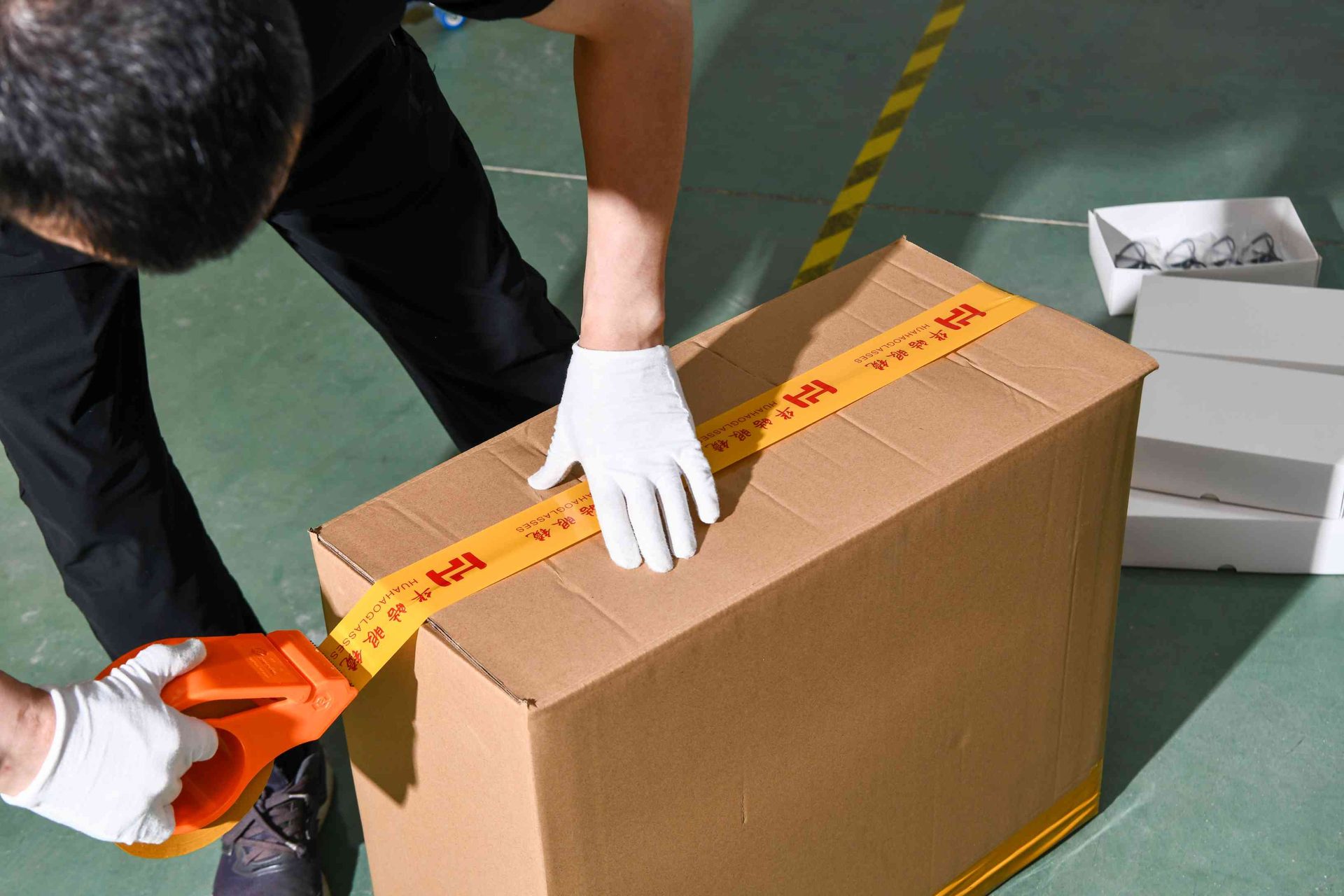 Sealing an export carton with HAO Eyewear branded packing tape