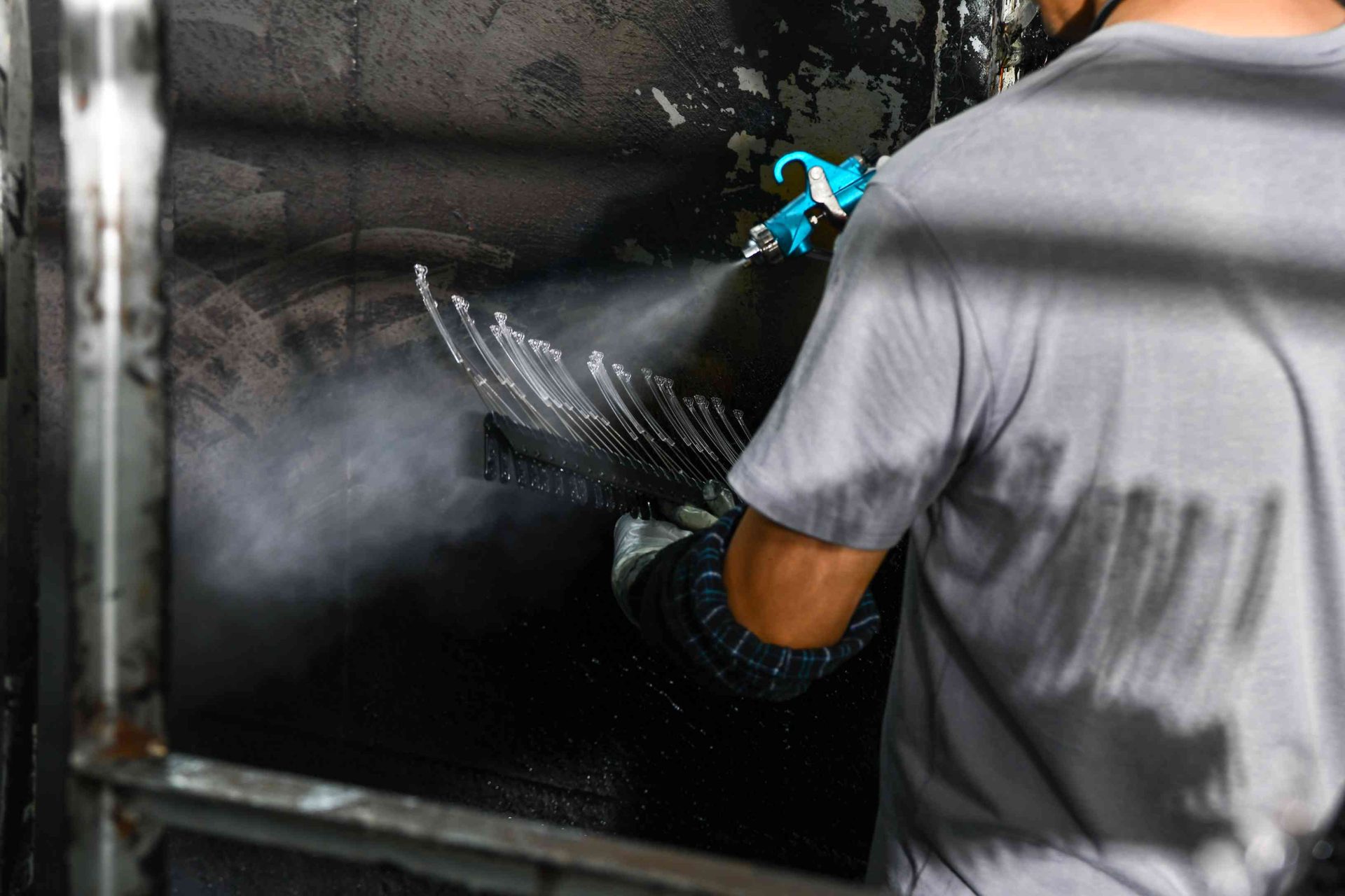 Precision spray-painting of eyewear frames with visible mist at HAO Eyewear