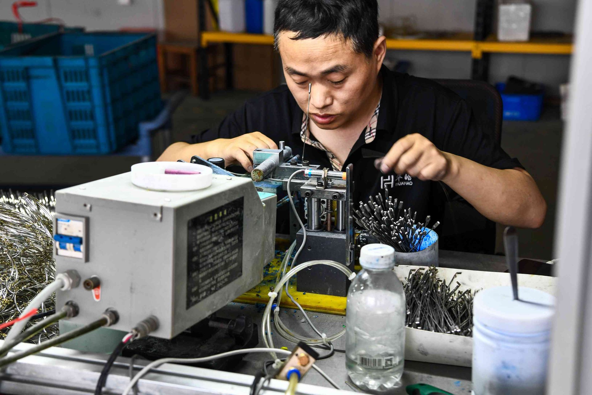 HAO Eyewear branded-uniform worker performing precision metal frame welding in Danyang